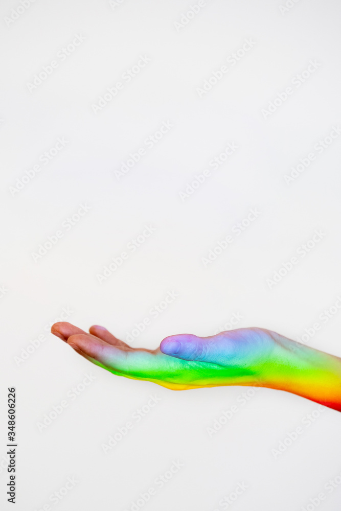 Gay price colors reflected on a hand isolated on white background. Sexual orientation in young people. Homosexual community. Unrecognizable woman hand with a rainbow iconic reflection on the skin. Gay price colors reflected on a hand isolated on white background. Sexual orientation in young people. Homosexual community. Unrecognizable woman hand with a rainbow iconic reflection on the skin.