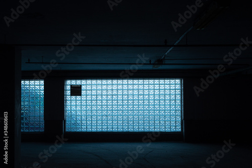 blue glass brick wall - seamless texture. color abstraction in brick glass wall. Dark room with a large window made of glass bricks.