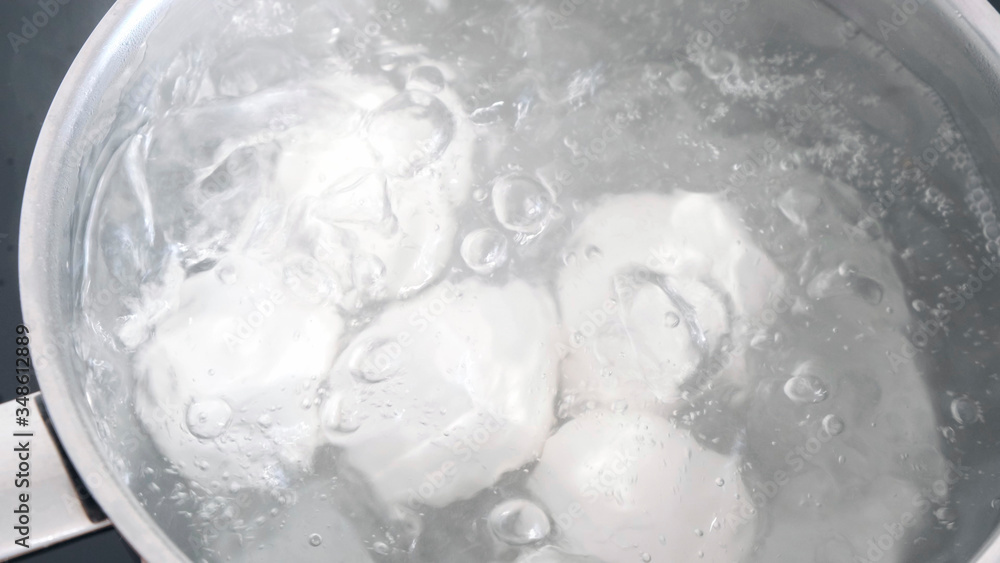 Chicken eggs boiling in stainless steel pan in water. Chicken eggs boiling in stainless steel pan in water.