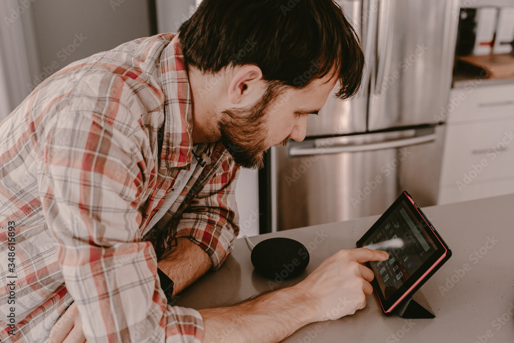 Young man millennial hipster orders food with tablet. Online food delivery. Ordering food online. Using app for delivery. Smart speaker. Smart home. Using modern technology at home. Making phone call Young man millennial hipster orders food with tablet. Online food delivery. Ordering food online. Using app for delivery. Smart speaker. Smart home. Using modern technology at home. Making phone call