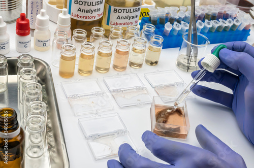 Experienced laboratory scientist analyzing a sample from a canned food can, botulism infection in sick people photo