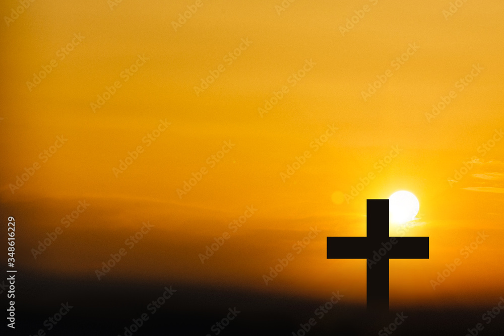 Silhouette of a cross on a sunset background.