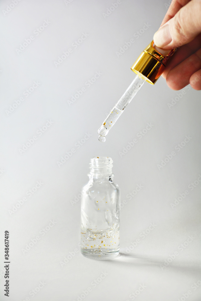 Luxurious facial serum container with dropper on gray background Luxurious facial serum container with dropper on gray background