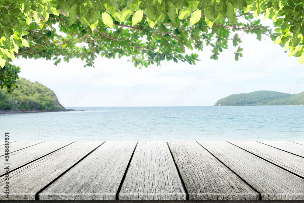 old wood table top on blurred beach background with coconut leaf
