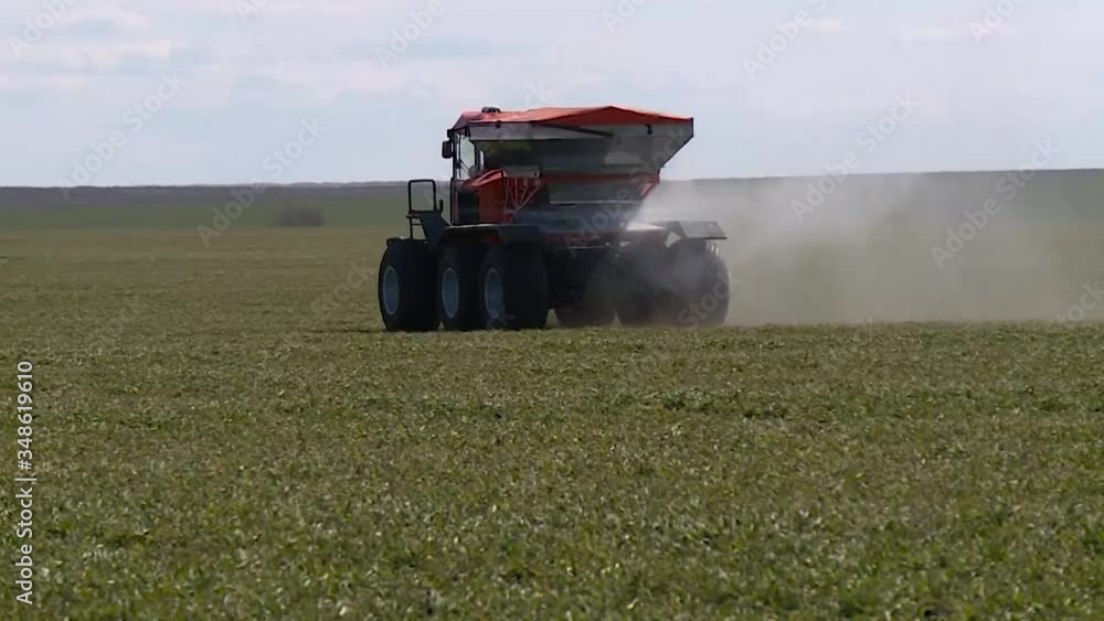 Self propelled sprayer fertilizer spreader rides on a green field