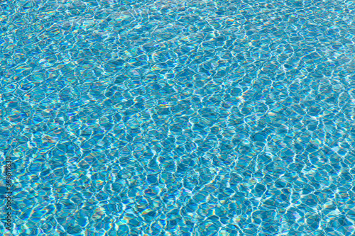 background of blue small tiles at a swimming pool with water structure
