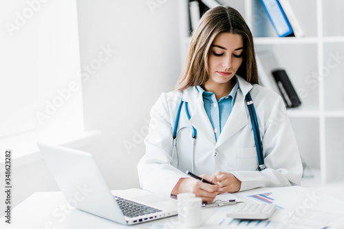 Female doctor working at office desk,  healthcare professionals.