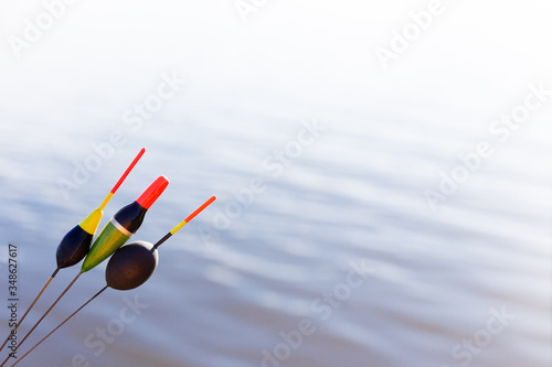 Three bright fishing floats on a background of calm water. Copyspace. Blurred background.