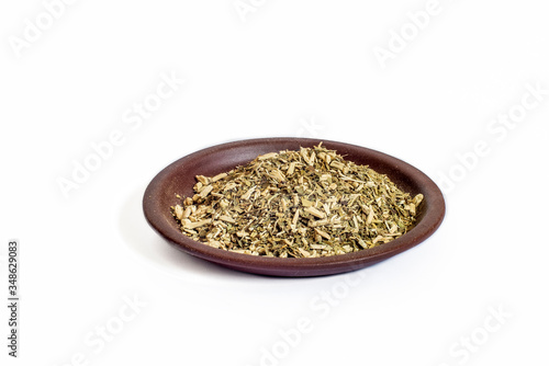 Yerba mate dry herb in clay bowl isolated on white background