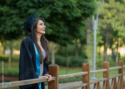 Woman taking a lot of different graduation photos in a beautiful botanical park.