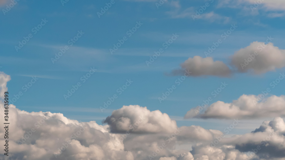 Lush, voluminous, white clouds in a clear blue sky with dark clouds, illuminated by the rays of the sun on a Sunny day. Lush, voluminous, white clouds in a clear blue sky with dark clouds, illuminated by the rays of the sun on a Sunny day.