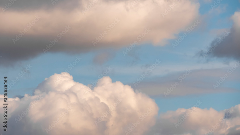 Sky with clouds. Lush, large Cumulus clouds in a clear blue sky illuminated by the rays of the sun on a Sunny day. Realistic sky background. Template. Sky with clouds. Lush, large Cumulus clouds in a clear blue sky illuminated by the rays of the sun on a Sunny day. Realistic sky background. Template.