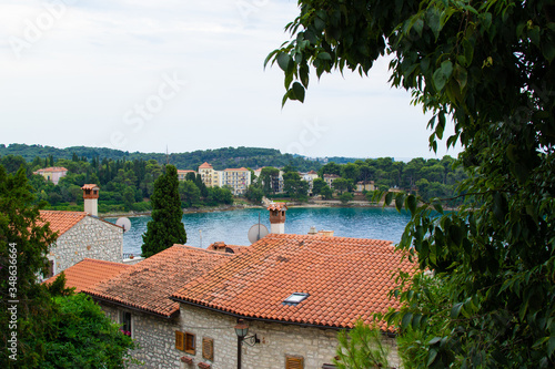 View of the Adriatic Sea with the roofs of the typical croatian houses and the green vegetation in the land, in Rovinj, Croatia