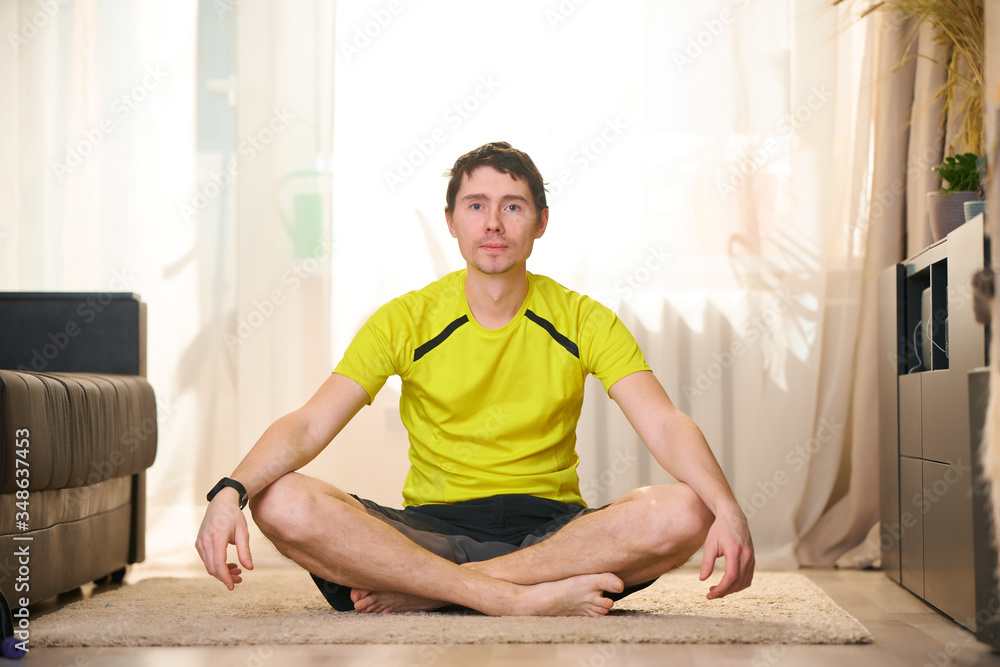 Woman practices yoga and meditates in the lotus position at home. Woman practices yoga and meditates in the lotus position at home.
