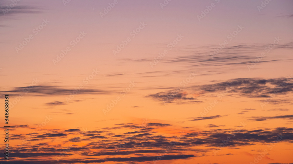 The sky at sunrise or sunset. Beautiful gradient with long, dark clouds in a clear sky. Template for the design.