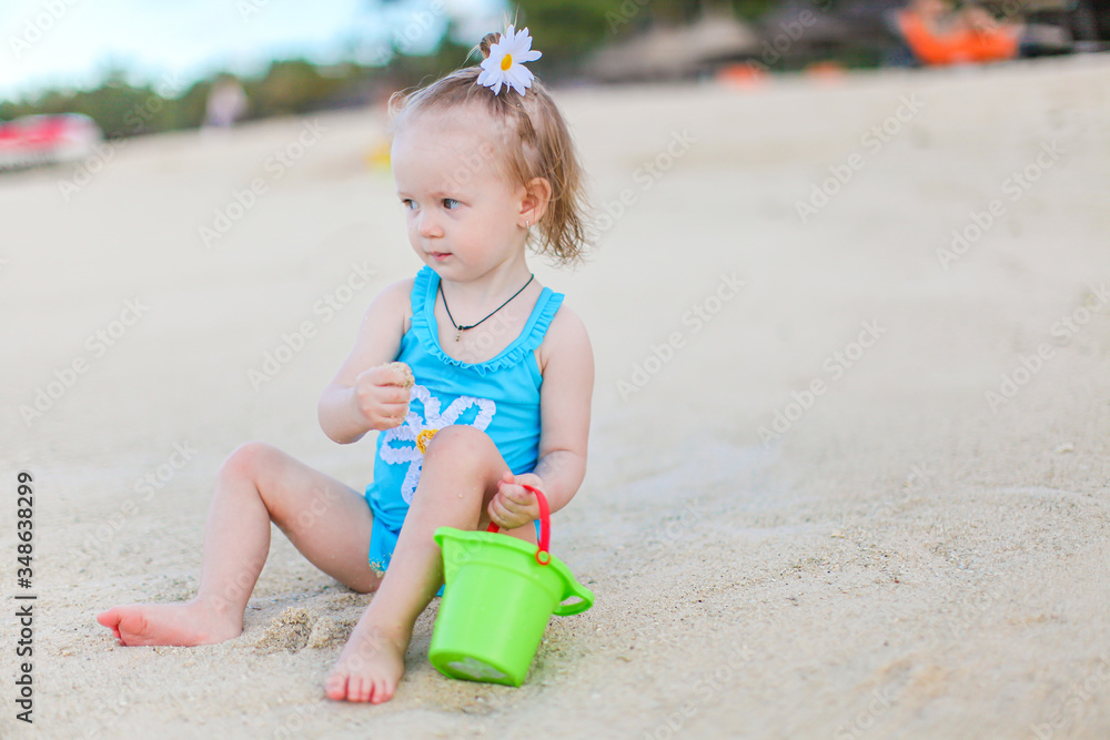 Little girl at tropical white beach making sand castle Little girl at tropical white beach making sand castle