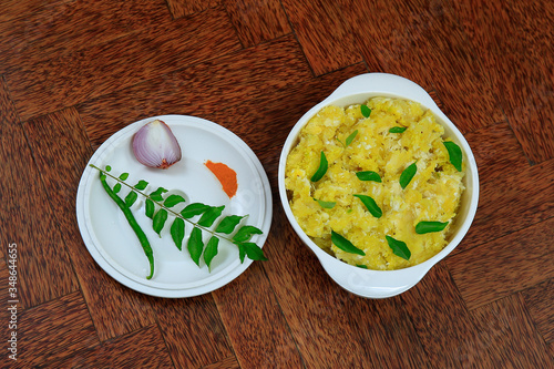 Tasty south indian kappa puzhukku, cooked tapioca in a white bowl isolated on wooden background photo