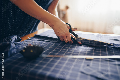 The seamstress cuts the fabric for the dress.