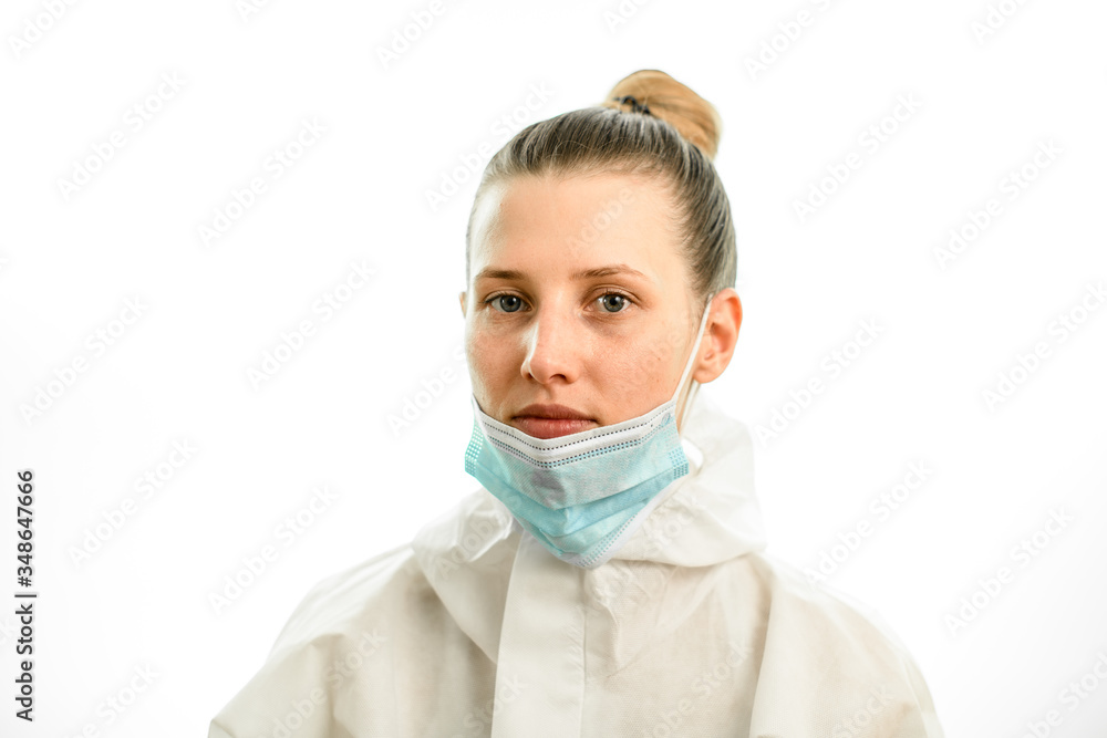 Portrait of young blonde woman with downcast medical mask on grey background Portrait of young blonde woman with downcast medical mask on grey background