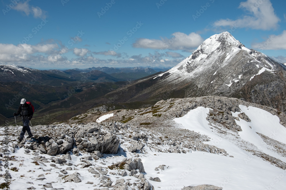 Montañero realizando una ruta con vistas al fondo del pico Espigüete, con una altitud de 2450 m, en el Parque Natural Montaña Palentina, en la cordillera Cantábrica. 