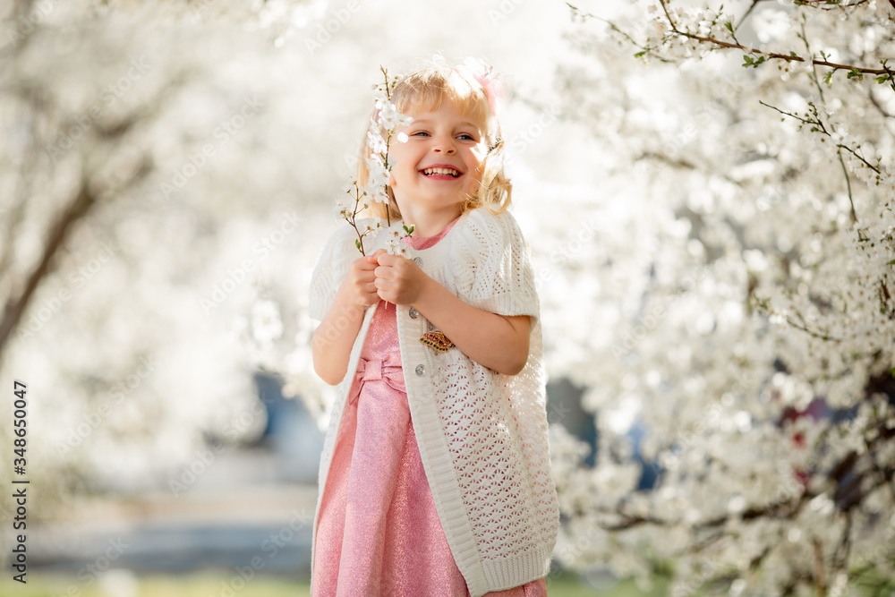 Cute little child girl is playing in blossom cherry garden outdoors. Cute little child girl is playing in blossom cherry garden outdoors.