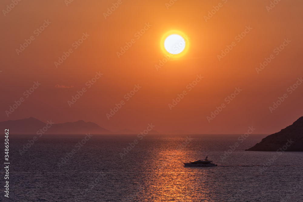 A yacht on the reflected light in the sea at sunset