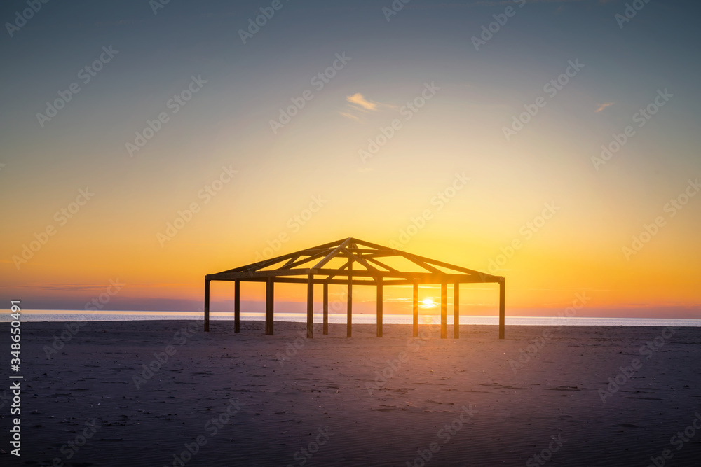 Silhouette Built Structure By Sea Against Orange Sky