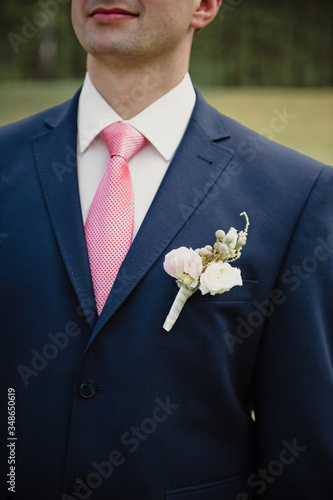 Wedding in the spring. The groom in a blue suit and pink tie. Portrait.