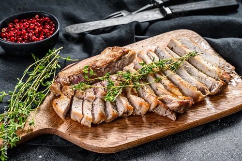 Sliced Grilled pork cutlets. Organic meat steak. Black background. Top view