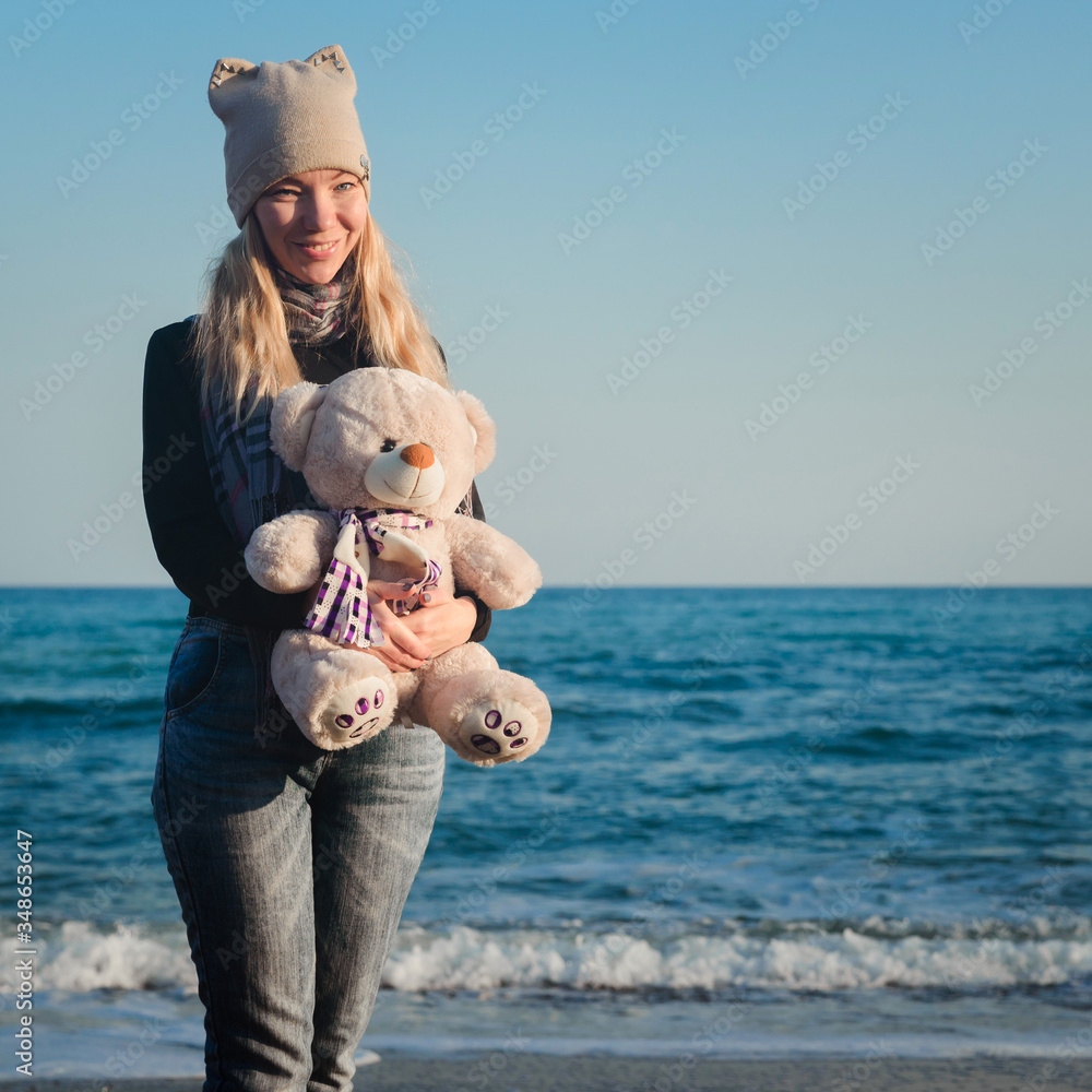 Girl on the beach plays with a teddy bear Girl on the beach plays with a teddy bear