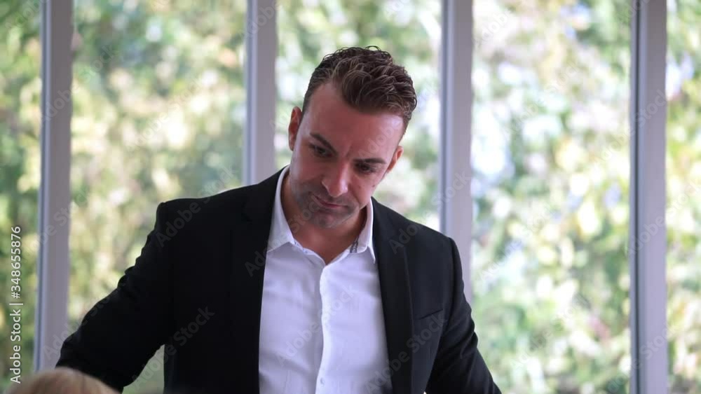 Caucasian businessmen, managers, standing and talking. Join the meeting with the staff team in the meeting room. Behind a large glass window Caucasian businessmen, managers, standing and talking. Join the meeting with the staff team in the meeting room. Behind a large glass window