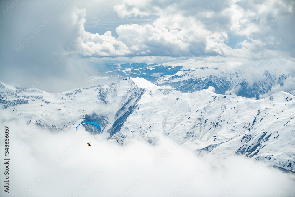 Paragliding  in Gudauri ski resort winter. Caucasus mountains in Georgia