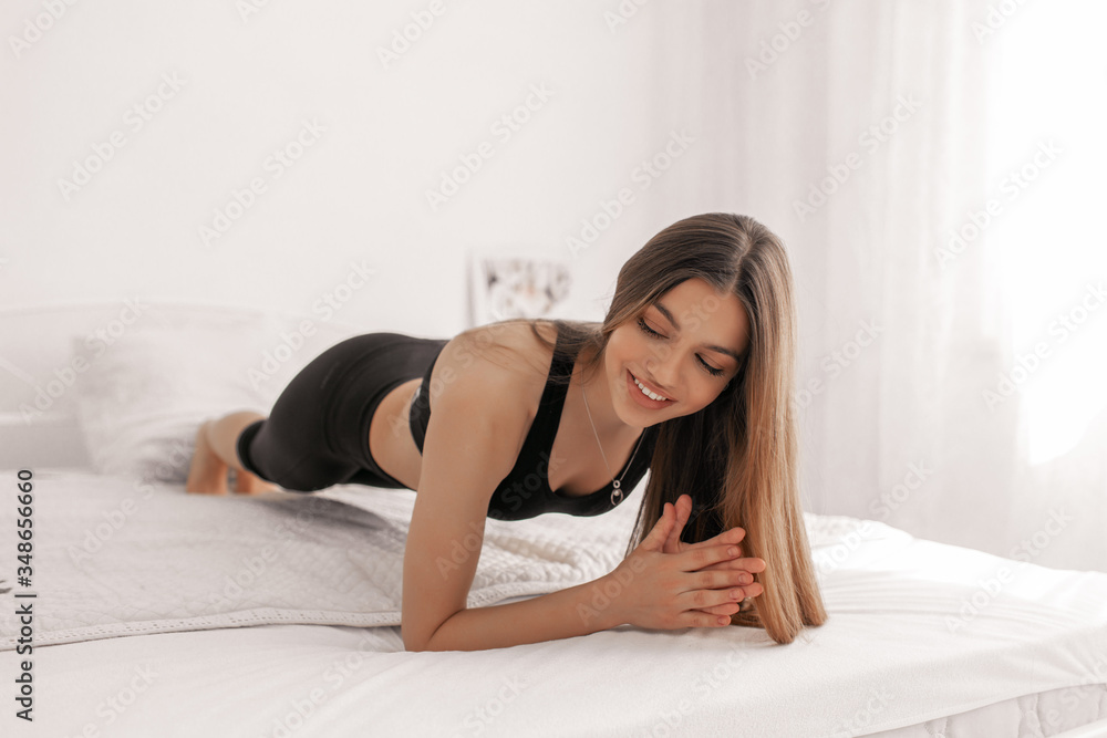 Pretty girl doing yoga exercise on bed at home. Healthy and sport lifestyle. Pretty girl doing yoga exercise on bed at home. Healthy and sport lifestyle.