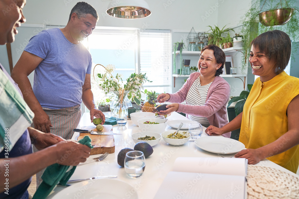 Happy mature couples cooking and eating in kitchen Happy mature couples cooking and eating in kitchen
