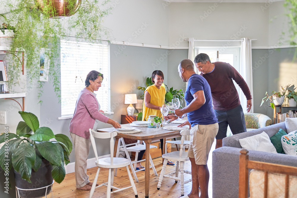 Mature couple friends setting dining table for lunch Mature couple friends setting dining table for lunch