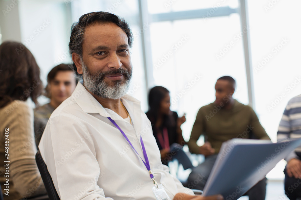 Portrait confident businessman with paperwork in office meeting Portrait confident businessman with paperwork in office meeting