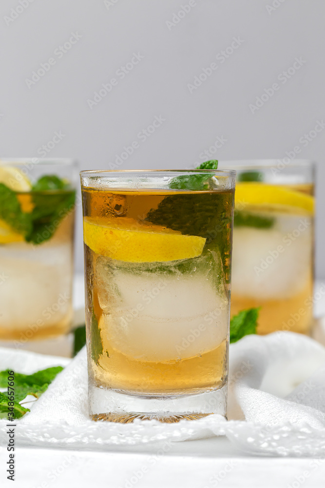 tea with ice, mint and lemon wedges on white table tea with ice, mint and lemon wedges on white table
