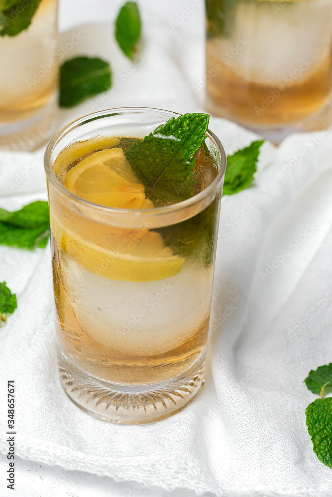 tea with ice, mint and lemon wedges on white table tea with ice, mint and lemon wedges on white table