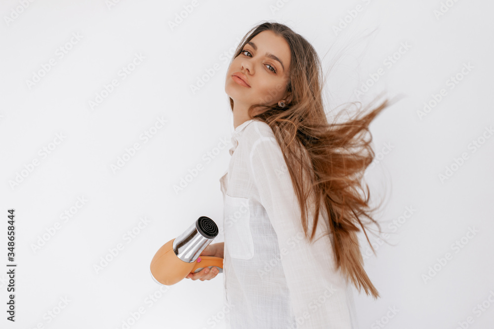 Beautiful teenage girl blowing her hair with hairdryer. Beauty and hait concept. Beautiful teenage girl blowing her hair with hairdryer. Beauty and hait concept.