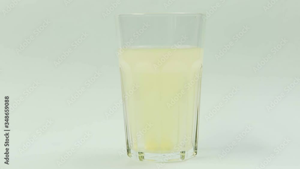Pill falling down in glass with water. effervescent tablet aspirin. closeup on white background Pill falling down in glass with water. effervescent tablet aspirin. closeup on white background