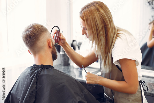 Man with a beard. Hairdresser with a client. Woman shaving a man's beard
