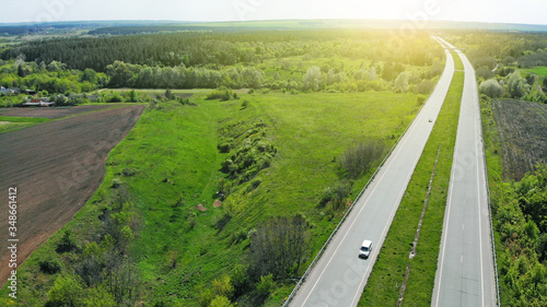 Aerial. Two-lane road between agricultural fields. View above from drone.