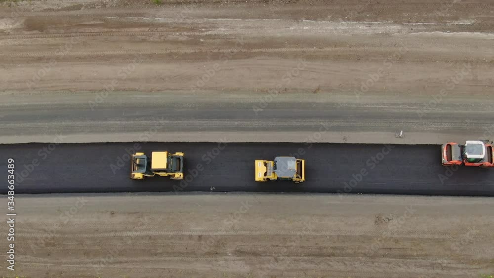Roller machines make new asphalt roads. The asphalt paver squeezes hot asphalt. Roller machines make new asphalt roads. The asphalt paver squeezes hot asphalt.