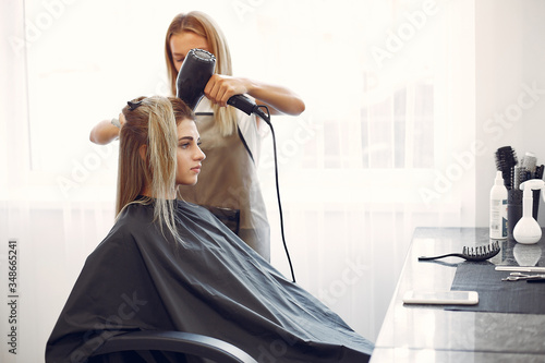 Hairdresser drying head her client. Woman in a hair salon