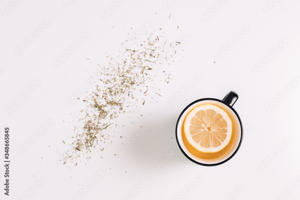 A cup of herbal tea with lemon on white table, top view