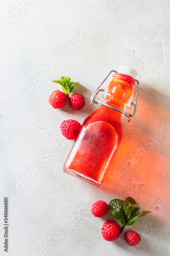 Homemade raspberry vinegar and fresh raspberries. photo