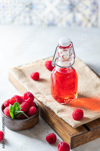 Homemade raspberry vinegar and fresh raspberries. photo