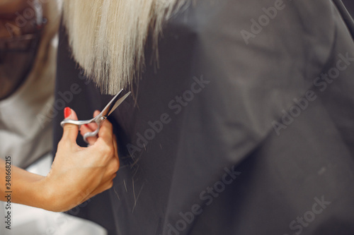 Hairdresser cut hair her client. Woman in a hair salon