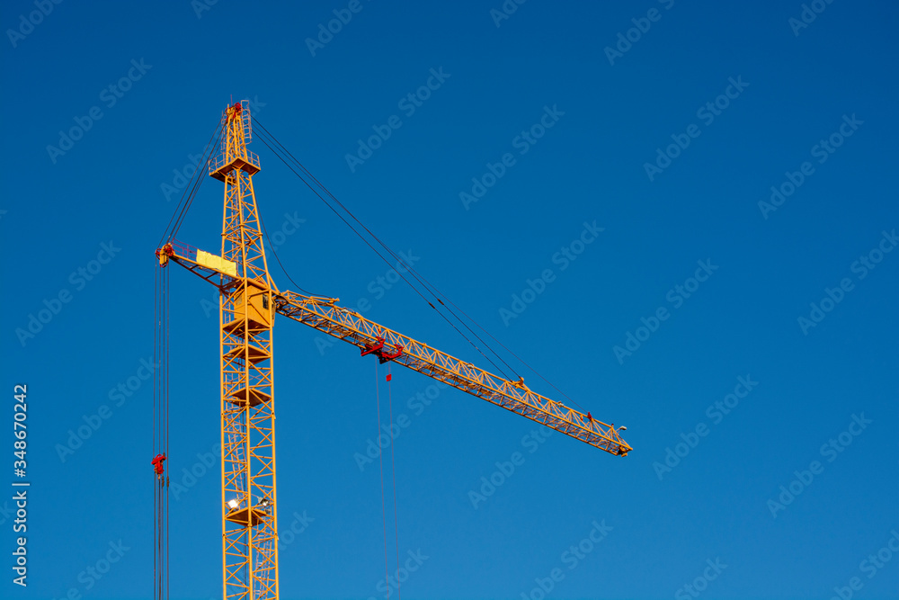 Crane. Construction crane. Huge crane against blue sky. Self-erection cranr. Tower crane. Crane. Construction crane. Huge crane against blue sky. Self-erection cranr. Tower crane.