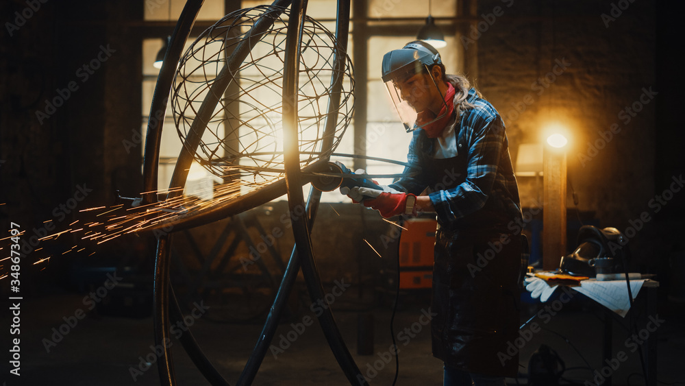Shot of Talented Innovative Female Artist Using an Angle Grinder to Make Abstract, Brutal and Expressive Metal Sculpture in a Workshop. Contemporary Fabricator Creating Modern Steel Art. Shot of Talented Innovative Female Artist Using an Angle Grinder to Make Abstract, Brutal and Expressive Metal Sculpture in a Workshop. Contemporary Fabricator Creating Modern Steel Art.